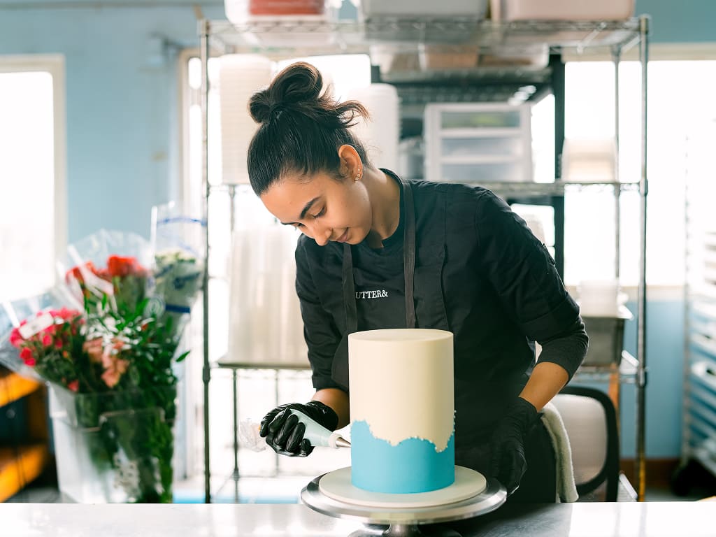 A Xero user decorating a cake with blue icing.